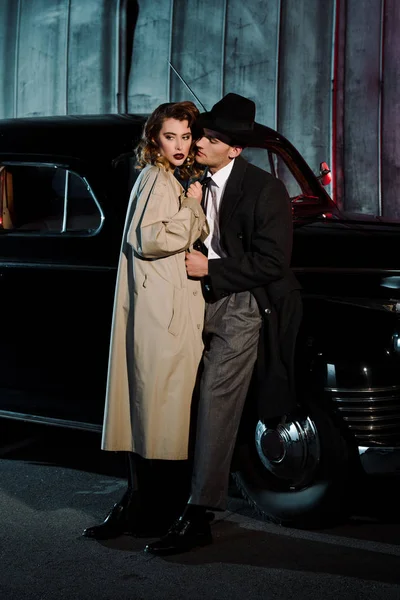 Handsome gangsters standing near retro car outside — Stock Photo