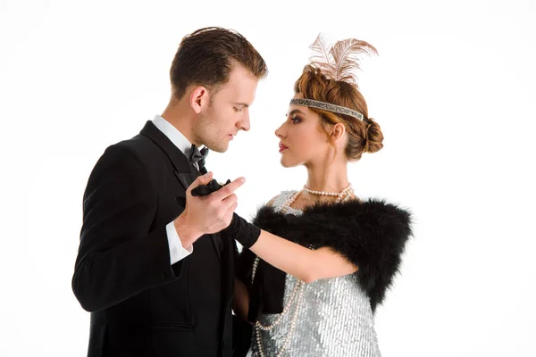 Vista lateral de hombre y mujer guapos en collar de perlas sosteniendo las manos aisladas en blanco - foto de stock