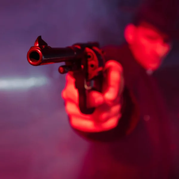 Selective focus of black gun in hand of dangerous man — Stock Photo