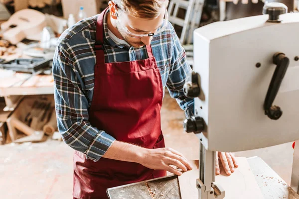 Selektiver Fokus des bärtigen Tischlers in Schutzbrille mittels CNC-Maschine — Stockfoto