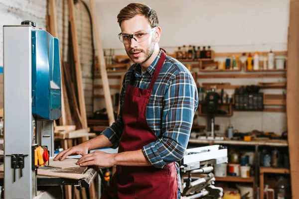 Schöner Holzarbeiter mit Schutzbrille blickt in die Kamera — Stockfoto