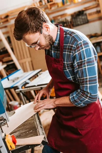 Carpinteiro em óculos de segurança e avental usando máquina cnc — Fotografia de Stock