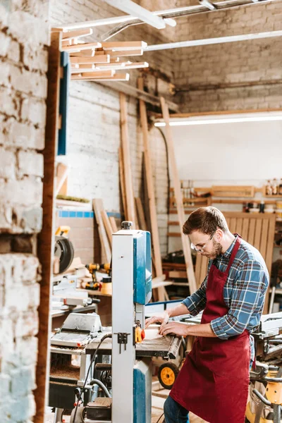 Foyer sélectif du travailleur du bois barbu dans les lunettes en utilisant la machine cnc dans l'atelier — Photo de stock