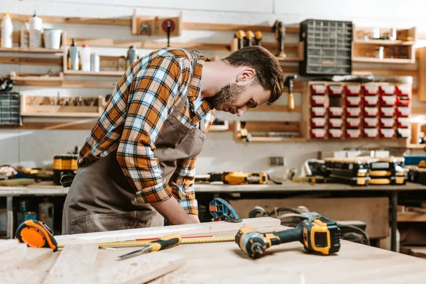 Selektiver Fokus des bärtigen Zimmermanns in brauner Schürze — Stockfoto