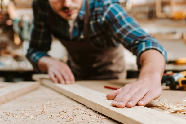 Vue recadrée du menuisier touchant une planche de bois — Photo de stock