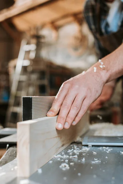 Selective focus of sawdust on hands on carpenter — Stock Photo