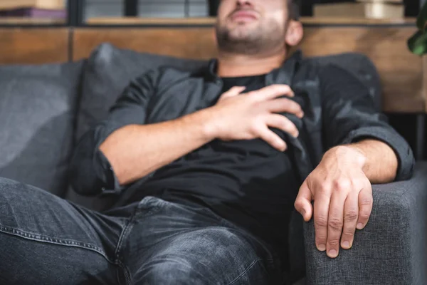 Selective focus of man with having heart attack in apartment — Stock Photo