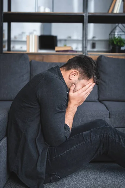 Seitenansicht eines Mannes mit Panikattacke, der in Wohnung weint — Stockfoto