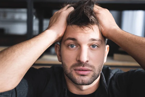 Handsome man with panic attack touching head in apartment — Stock Photo