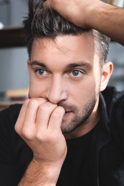 Hombre guapo con ataque de pánico tocando la cabeza en el apartamento - foto de stock