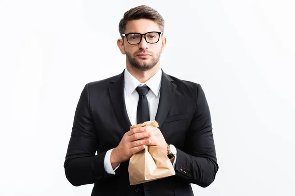 Asustado hombre de negocios en traje sosteniendo bolsa de papel durante conferencia aislado en blanco - foto de stock