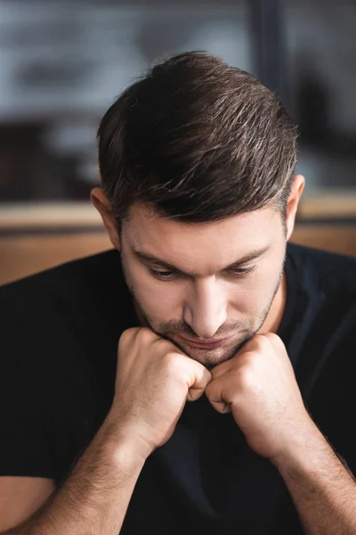 Schöner und trauriger Mann im T-Shirt, der in der Wohnung nach unten schaut — Stockfoto