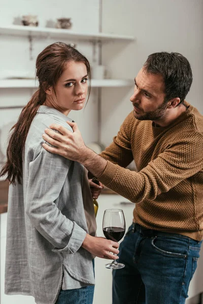 Mann streitet sich mit alkoholabhängiger Frau in Küche — Stockfoto