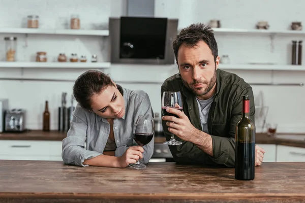 Alcohol pareja adicta beber vino en la cocina - foto de stock