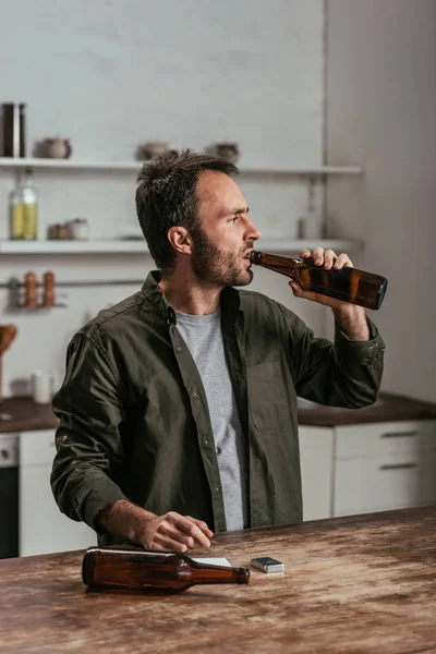 Uomo alcolizzato che beve birra in cucina — Foto stock