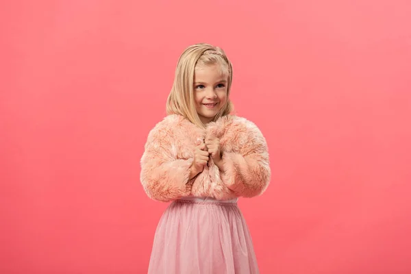 Niedliches und lächelndes Kind im Pelzmantel isoliert auf rosa — Stockfoto