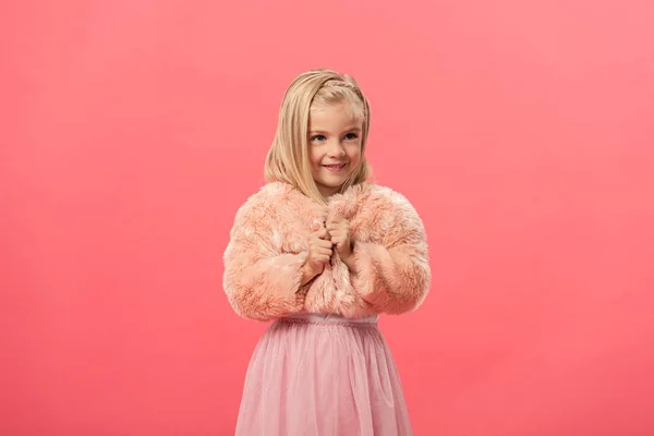 Mignon et souriant enfant en manteau de fourrure isolé sur rose — Photo de stock