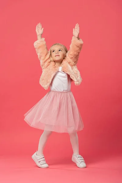 Cute and stylish kid in with outstretched hands on pink background — Stock Photo