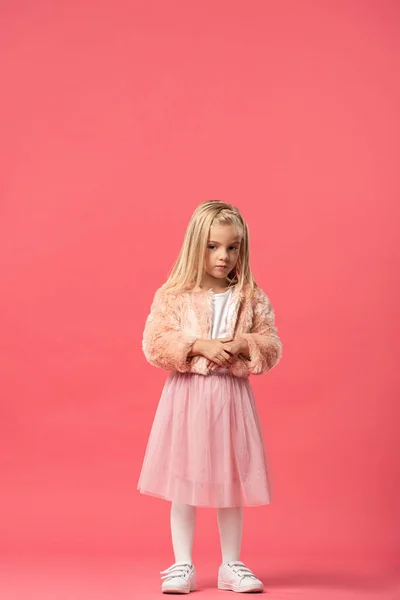 Mignon enfant en manteau de fourrure regardant loin sur fond rose — Photo de stock