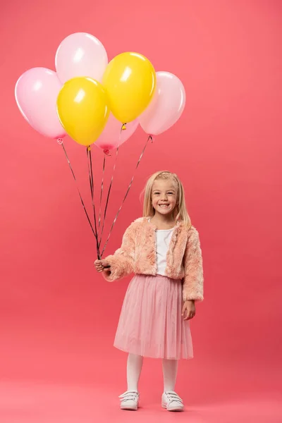 Niedliches und lächelndes Kind mit Luftballons auf rosa Hintergrund — Stockfoto