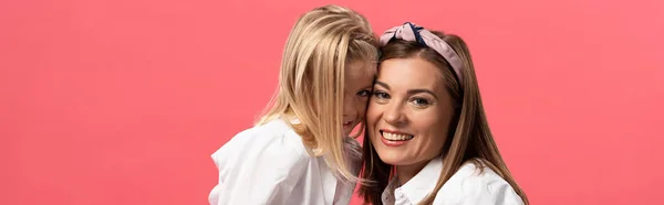 Панорамний знімок усміхненої дочки і матері, дивлячись на камеру ізольовано на рожевому — стокове фото