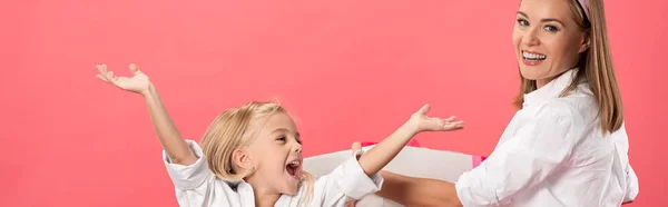 Plano panorámico de hija en caja de regalo con las manos extendidas y madre sonriente aislada en rosa - foto de stock