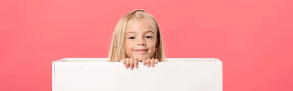 Panoramic shot of cute and smiling kid in gift box isolated on pink — Stock Photo