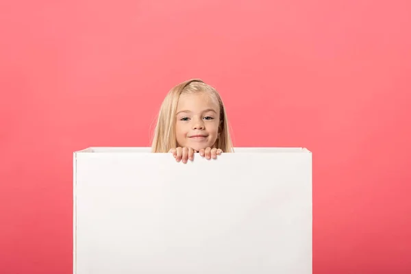 Lindo y sonriente niño en caja de regalo aislado en rosa - foto de stock