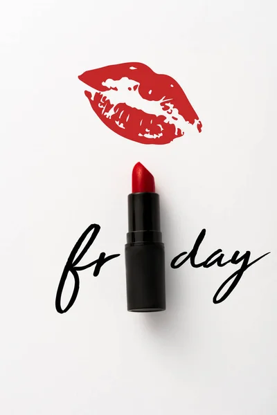 Top view of black tube with red lipstick near friday letters and kiss print on white — Stock Photo