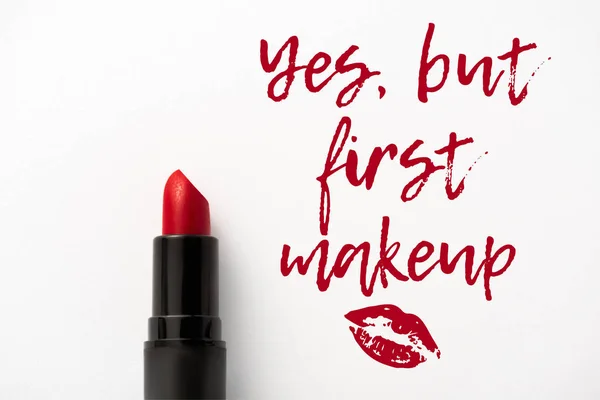 Top view of red lipstick near yes, but first makeup letters and kiss print on white — Stock Photo