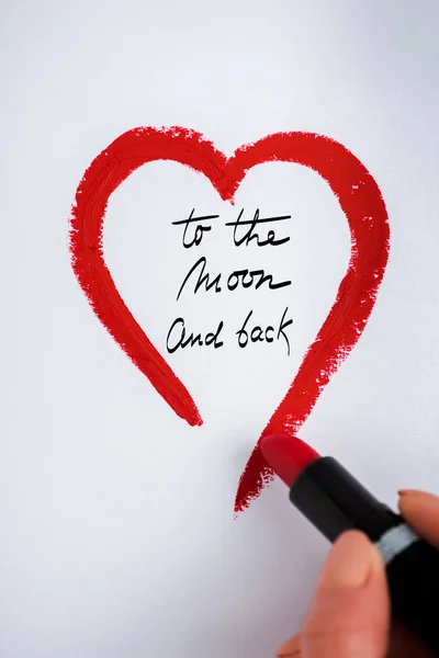 Vista recortada de la mujer dibujando corazón con lápiz labial rojo cerca de la luna y letras de fondo en blanco - foto de stock