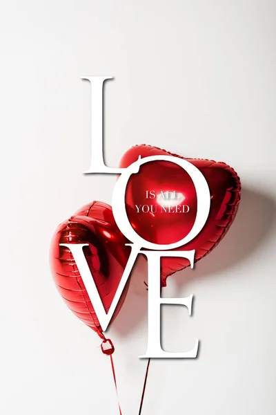 Красные и блестящие шары в форме сердца рядом со всем, что вам нужно любовные письма на белом — стоковое фото