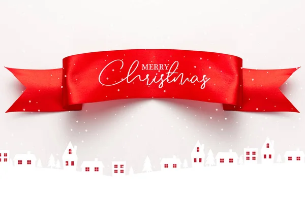 Top view of red satin ribbon with merry christmas lettering near houses and pines on white — Stock Photo