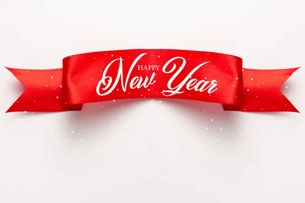 Draufsicht auf rotes Satinband mit frohem neuen Jahr Schriftzug auf Weiß — Stockfoto