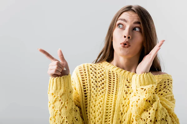 Ragazza sorpresa che punta con il dito mentre distoglie lo sguardo isolato sul grigio — Foto stock