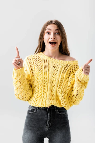 Excitada chica mostrando idea signo y pulgar hacia arriba mientras mira a la cámara aislada en gris - foto de stock