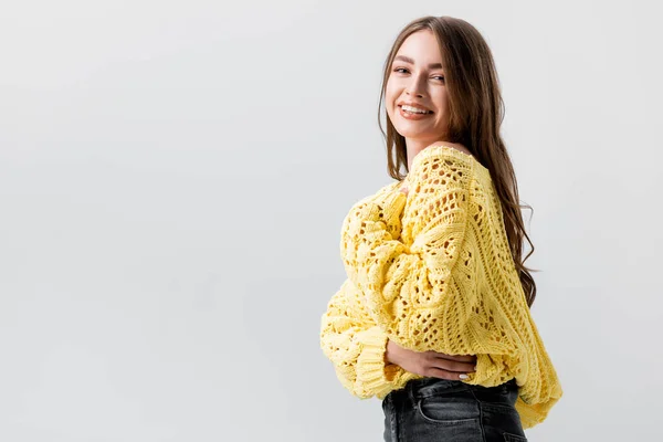 Alegre chica riendo y sosteniendo la mano en el pecho mientras mira la cámara aislada en gris - foto de stock