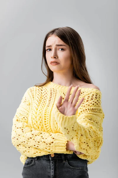 Menina descontente em suéter amarelo mostrando gesto de recusa e olhando para a câmera isolada no cinza — Fotografia de Stock