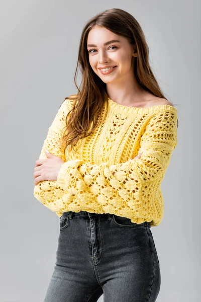 Attractive girl in yellow sweater smiling at camera isolated on grey — Stock Photo