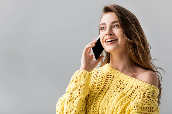 Happy girl looking away while talking on smartphone isolated on grey — Stock Photo