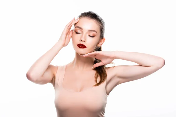 Atraente jovem mulher tocando o rosto com os olhos fechados isolados no branco — Fotografia de Stock