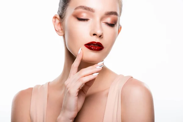 Atractiva joven tocando la cara con los ojos cerrados aislados en blanco — Stock Photo