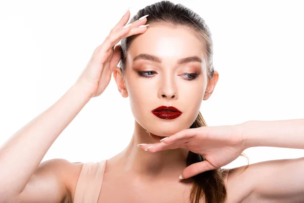 Beautiful young woman with makeup touching face isolated on white — Stock Photo