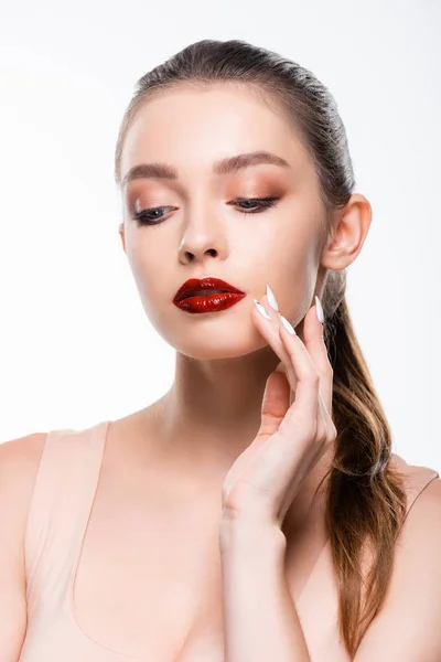 Hübsche junge Frau mit leuchtend roten Lippen berühren Gesicht isoliert auf weiß — Stockfoto