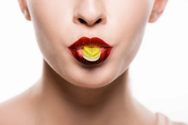 Vista cortada da mulher com lábios vermelhos segurando doces na boca isolado no branco — Fotografia de Stock
