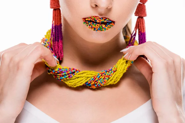 Vista ritagliata di ragazza con perline sulle labbra toccando collana di perline isolato su bianco — Foto stock