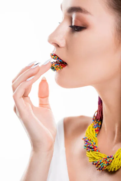 Cropped view of girl in beaded necklace touching beads on lips isolated on white — Stock Photo