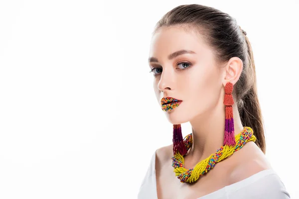 Beautiful girl in beaded accessories, with beads on lips, looking at camera isolated on white — Stock Photo