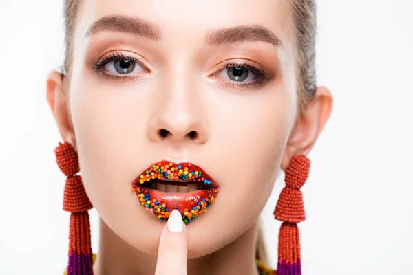 Beautiful girl touching lips, decorated with beads, and looking at camera isolated on white — Stock Photo