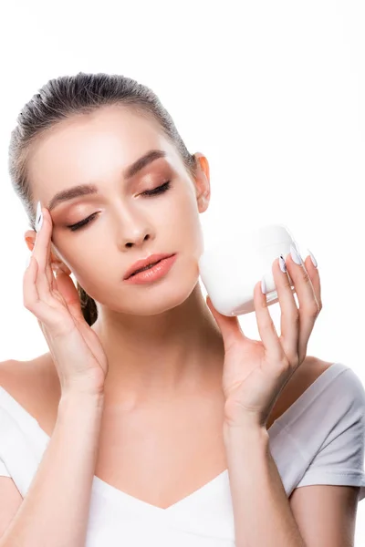 Beautiful girl applying face cream with closed eyes isolated on white — Stock Photo